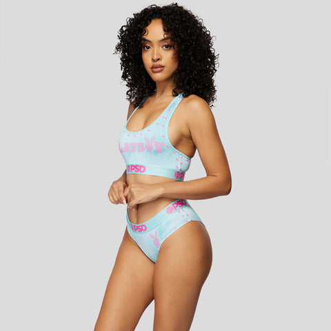 curly-haired model wearing teal and pink cheeky underwear and bra set with playboy bunny logo | PSD New Zealand